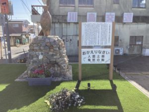 人面土器とそれに関する説明看板。 下部には「おかえりなさい/人面土器/鬼怒の鮭」とある。