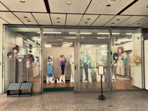 フォトスポット入り口。
ガラスにミニキャラのアイドルが貼ってあり、中のパネルが見える。