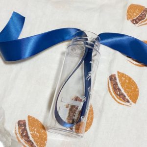 透明なミニボトルにリボンを差し込んでいる写真。