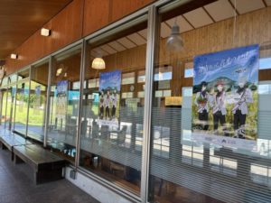 食事処の外側。ドラスタのポスターが1つの窓につき1枚中央に貼ってある。