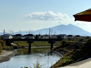 手前に川、奥に筑波山が見える。