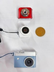 Digital Snap Camera microと3X MINI DV CAMERAとvogueと10円玉を並べた写真。Digital Snap Camera microが一番小さくだいたい10円玉程度。
